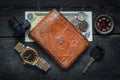 Wallet, watch, camera, compass, vehicle key, dollar bill and coins on a rustic wood background Royalty Free Stock Photo