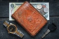 Wallet; watch; vehicle key, dollar bill and coins on a rustic wood background Royalty Free Stock Photo