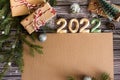 Flat lay welcome new year card with place for your text, craft gifts with fir branches and numbers 2022 on dark wooden background Royalty Free Stock Photo