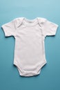 Flat lay of white baby grow with copy space on blue background