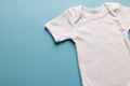 Flat lay of white baby grow with copy space on blue background