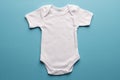 Flat lay of white baby grow with copy space on blue background