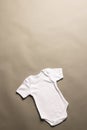 Flat lay of white baby grow with copy space on grey background