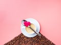 A white cup with coffee stands on a hill of coffee beans on a pink background Royalty Free Stock Photo