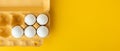 Flat lay of white eggs in the carton brown box on the yellow background. Top view. Breakfast in the morning concept with copy Royalty Free Stock Photo