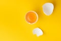 Flat lay of white eggs in the carton brown box on the yellow background. Top view of broken egg with white shell. Copy space for a Royalty Free Stock Photo