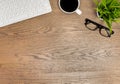 Flat lay, Wood office desk table. View from above with keyboard, computer mouse, notebooks, eyeglasses and cup of black coffee on Royalty Free Stock Photo