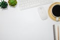 Flat lay, White office desk table. View from above with keyboard, computer mouse, pencil, notebooks and cup of black coffee on woo Royalty Free Stock Photo