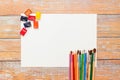 Flat lay of white Paper, watercolors, paint brush and colour pencils on wooden table Royalty Free Stock Photo