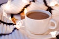 Flat lay. White porcelain cup with coffee with milk, sweater, coarse knitted textile, black and white stripe safe candles, gold st