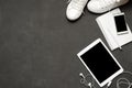 Flat lay Of White Sneakers On black Background with phone, headphones, tablet, copy book