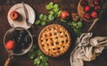 Flat-lay of whole apple and plum pie and tea setting