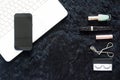 Flat lay of woman cosmetics with black mobile device