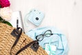 Flat lay woman handbag with elegant feminine accessories on wooden desk. Top view instant photo camera, glasses, gift box, blue