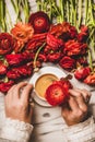 Womans hand holding red flower over table with coffee Royalty Free Stock Photo