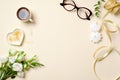 Flat lay women home office desk with coffee cup, glasses, roses flowers bouquet, paper clip, ribbon and feminine golden fashion