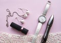 Flat lay women`s accessories collage with stylish watches, earrings and pendant with white pearls, lipstick, mascara on a Lacy Royalty Free Stock Photo