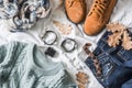 Flat lay women`s clothing for autumn walks, top view. Brown suede boots, jeans, a blue pullover, scarf, bracelets, watches, headp