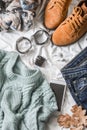 Flat lay women`s clothing for autumn walks, top view. Brown suede boots, jeans, a blue pullover, scarf, bracelets, watches, headp Royalty Free Stock Photo