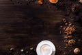 Flat lay wooden background dark brown wood. A cappuccino cup, sprinkled sugar, nuts