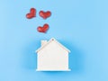 Flat lay of wooden model house with red glitter heart on blue background. dream house , home of love, strong relationship, Royalty Free Stock Photo