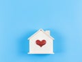 Flat lay of wooden model house with red glitter heart on blue background. dream house , home of love, strong relationship, Royalty Free Stock Photo