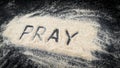 Flat lay of word PRAY written on white sand Royalty Free Stock Photo