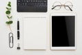 Flat lay work place. White office desk table with laptop, clips, glasses, notebook and pen. Top view with copy space