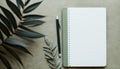 Flat Lay work scene consisting of pen, notebook and olive tree leaf