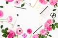 Flat lay workspace with clipboard, pink flowers and accessories on white background. Flat lay, top view. Copy space Royalty Free Stock Photo