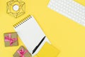 Flat lay yellow work space, key board note book and gift boxes with pink ribbon, Yellow background, copy space Royalty Free Stock Photo