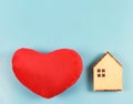 Flat layout of wooden model house and red heart shape pillow  isolated  on blue  background with copy space, dream home or home of Royalty Free Stock Photo