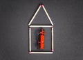 Flat match house with a miniature fire extinguisher inside.Creative property fire insurance concept