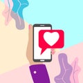 flat minimal woman hand holding mobile phone ith pink heart like social media icon with shadow on pastel colored blue and pink Royalty Free Stock Photo