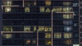 Flat night panorama of multicolor light in windows of multistory buildings aerial timelapse.