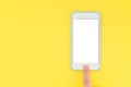 Flat picture of smartphone and finger. A person with his finger unlocks the smartphone on a yellow background. Top view