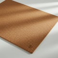 A flat, rectangular cork sheet with a light brown color is placed on a white surface. The Royalty Free Stock Photo