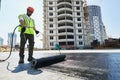 Flat roof construction and insulation. Heating and melting bitumen roofing felt Royalty Free Stock Photo