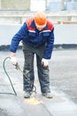 Flat roof covering repair works with roofing felt Royalty Free Stock Photo