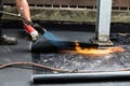 Flat roof installation. Heating and melting bitumen roofing felt Royalty Free Stock Photo