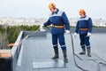 Flat roof installation. Heating and melting bitumen roofing felt Royalty Free Stock Photo