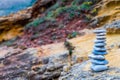 Flat stones stacked zen-like at a colorful rockface