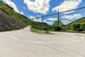 Flat straight Millau Viaduct above and old curly country road D41 on ground beneath. Aveyron, Occitania