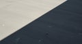 A flat surface, possibly concrete, is divided by a diagonal shadow, creating a contrast Royalty Free Stock Photo