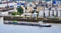 Flat tanker for inland canal transport sails in front of the quay wall of the oil port on the river Elbe Royalty Free Stock Photo