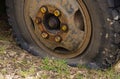 A flat tire of an old fragment of a rusty abandoned broken truck.