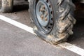 Flat tire of tractor on asphalt road, big car wheel wait for repair, maintanance in farm transportation Royalty Free Stock Photo