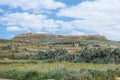 Flat topped plateau hill in the rural village of Ghasri, Gozo, Malta, with the Ta Giordan lighthou