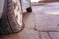 Flat tyre on road. Car tire leak because of nail pounding. Toned Royalty Free Stock Photo