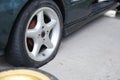 Flat tyre on road. Car tire leak because of nail pounding. Wheel damage on a road. Royalty Free Stock Photo